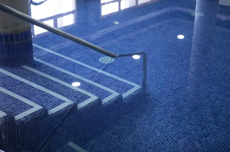 piscina termal cubierta con escaleras de acceso en el balneario de la concepción y cabañas valle del cabriel