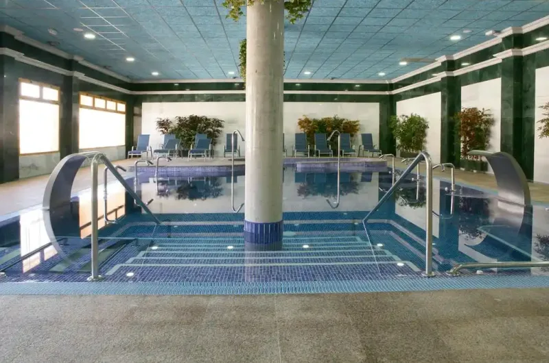 piscina cubierta con chorros de agua y zona de relajación en el balneario de la concepción y cabañas valle del cabriel