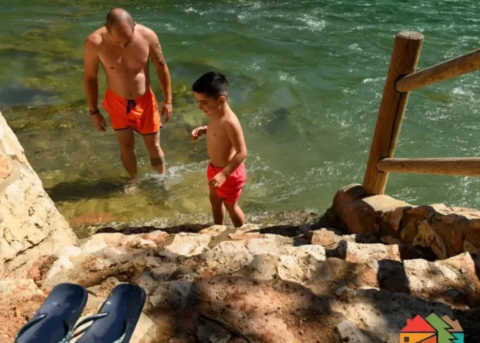 padre e hijo bañándose en el río cabriel junto a las cabañas rurales valle del cabriel en villatoya